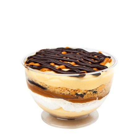 Layered banana dessert made of crispy cookies, custard, banana, salted caramel, chocolate and whipped cream isolated on whiteの写真素材