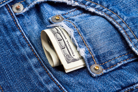 Rolled up one hundred dollar bills in jeans pocket