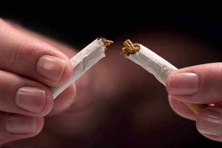 Woman's hands, breaking a cigaretteの写真素材