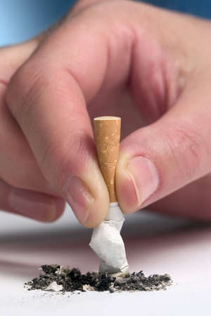 Woman's hand stubbing out a cigaretteの写真素材