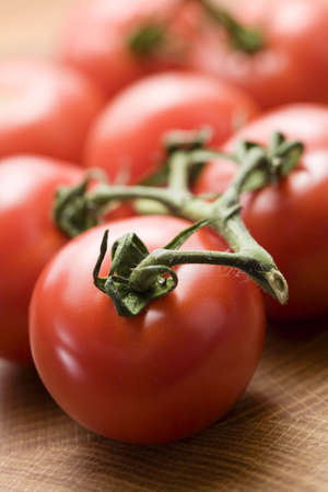 Close-up of vine tomatoes on wooden surfaceの写真素材