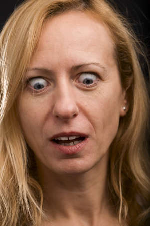 Mature blonde woman with surprised expression looking downの写真素材