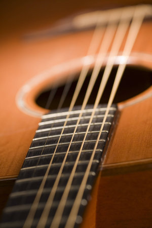 Close-up of acoustic guitar with vibrating strings - focus on fretboard