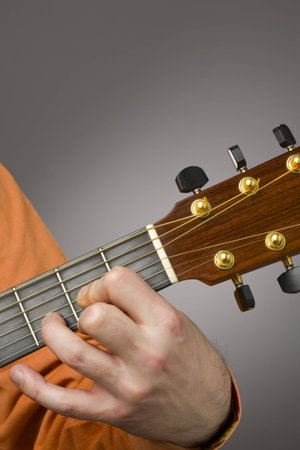 Close-up of acoustic guitar players left hand