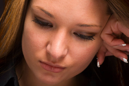 Close-up of attractive young woman looking down with serious expression