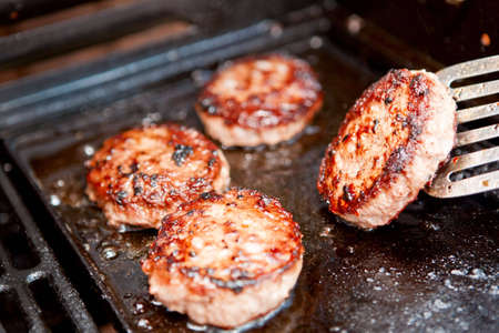 Burgers cooking on a barbecue - selective focusの写真素材