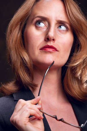 Portrait of serious businesswoman holding eye glassesの写真素材