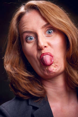 Portrait of a rude woman sticking her tongue outの写真素材