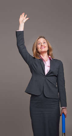 Happy business woman standing and waving her armの写真素材