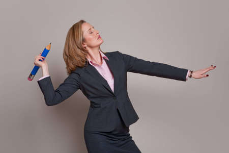 Businesswoman throwing a pencil like a spear or javelinの写真素材