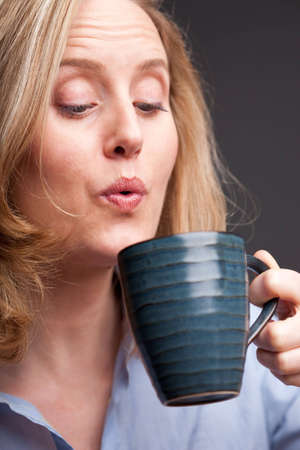 Portrait of blonde woman drinking from coffee mugの写真素材
