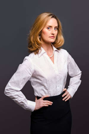 Portrait of a blonde woman wearing a white jacquard shirt on a grey backgroundの写真素材