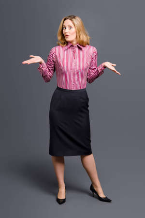 Standing woman wearing striped shirt and shrugging her shouldersの写真素材