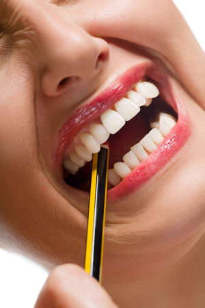 Close-up of stressed Caucasian woman biting pencil on white backgroundの写真素材