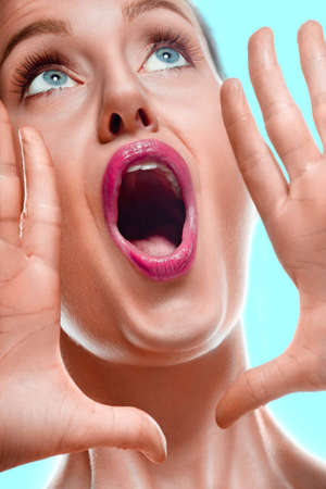 Close-up of woman shouting loud on white backgroundの写真素材