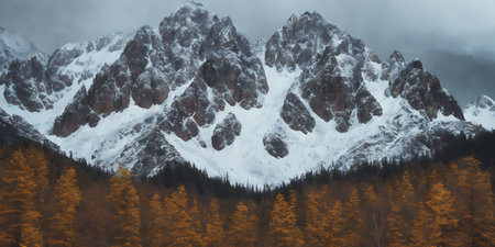 Mountain landscape with snowy peaks and coniferous forest in autumnの素材