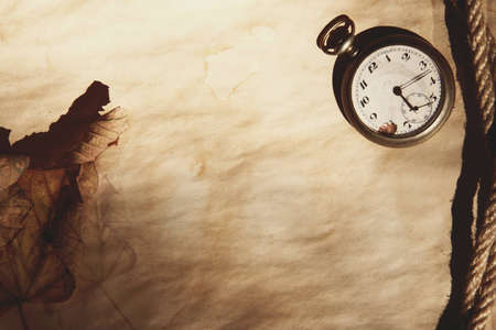 The old clock on the yellow paper, rope, fallen leafの写真素材