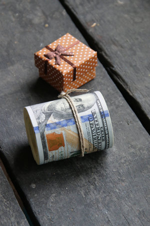 Money and brown gift on an old vintage tableの写真素材