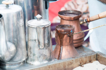 coffee preparation in copper pot with hot sandの写真素材