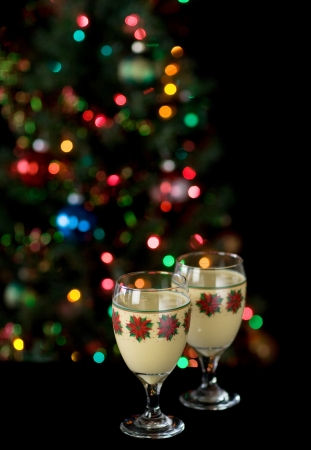 Two glasses of eggnog in front of christmas treeの写真素材