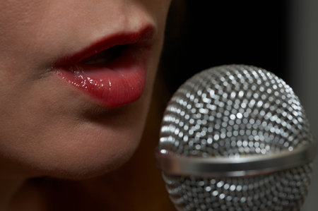 Woman singing into a microphone - closeup of microphone and mouthの写真素材