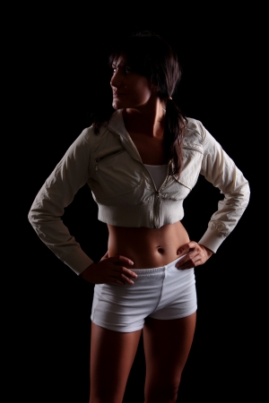 Fitness model shot on black background with lighting to show empasis on figure and formの写真素材
