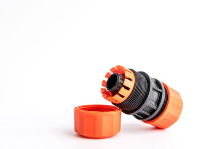 Orange garden water hose nozzle and connectors isolated on white background with soft shadow.