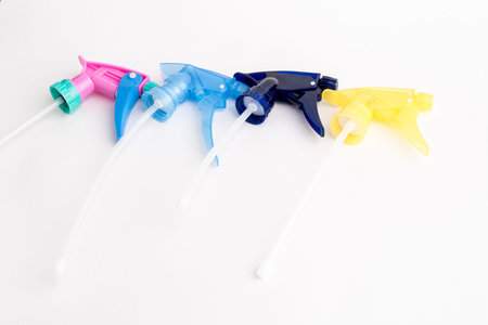 Small liquid atomizer of different colors on a white background, sprayer