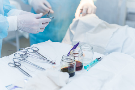 The assistant doctor transfers the surgical instruments to the doctor during the operation. The concept of a photo of professional quality medicineの写真素材