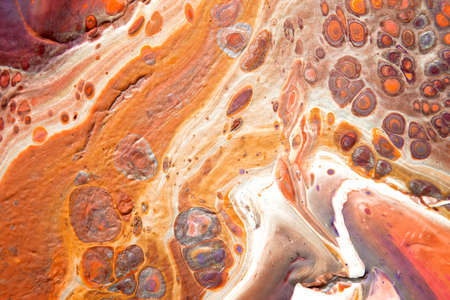 Spread-out acrylic paint. Abstract background, made in the technique of fluid art. Fashionable colorful background in warm colorsの写真素材