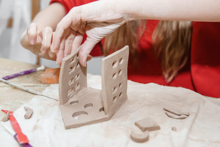 Womens hands knead clay, drawing elements of the product. Production of ceramic products at the...