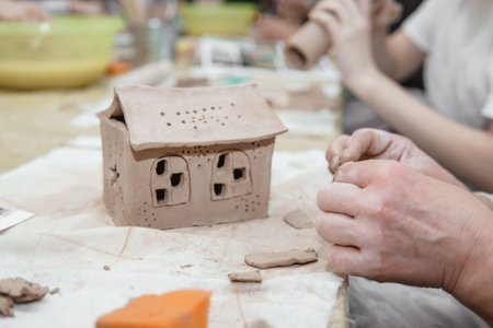 Womens hands knead clay, drawing elements of the product. Production of ceramic products at the master class on ceramics.の写真素材