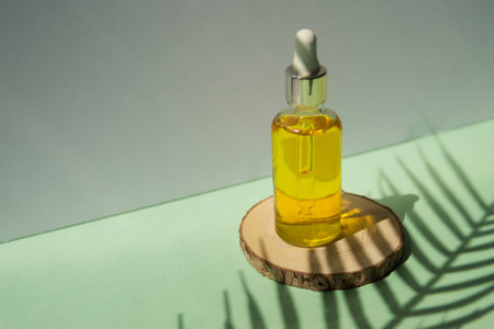 Cosmetic bottle with facial serum on a wooden podium. The concept of zero waste and ecology.の写真素材