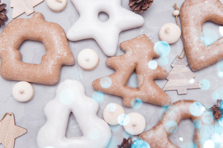 Banner for Christmas and New Year gingerbread stars, houses, Christmas trees, toys on a gray concrete background, Christmas lights bokeh in the foreground.の写真素材