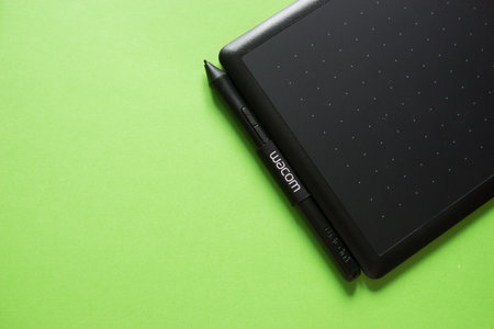Tver, Russia - February 3, 2020 Top view of Wacom graphic tablet on green background. Space for text.のeditorial素材