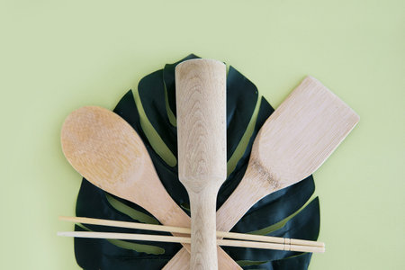 A set of eco-friendly bamboo Cutlery on green background. Concept of a waste-free lifestyle. Zero waste home.の写真素材