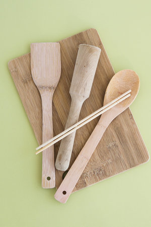 A set of eco-friendly bamboo Cutlery on green background. Concept of a waste-free lifestyle. Zero waste home.の写真素材