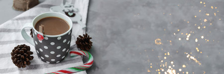 A large grey Cup of hot coffee drink with a Lollipop on a dark concrete background. Winter. Holiday concept, selective focus.の写真素材
