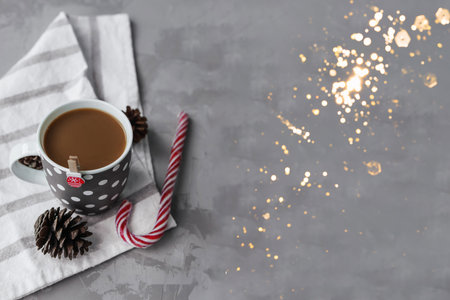 A large grey Cup of hot coffee drink with a Lollipop on a dark concrete background. Winter. Holiday concept, selective focus.の写真素材
