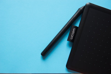 Tver, Russia - February 3, 2020 Top view of Wacom graphic tablet on blue background. Space for text.のeditorial素材