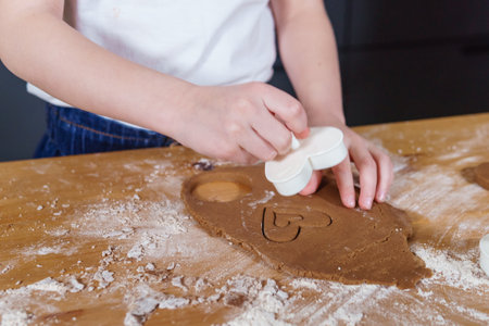 A little girl makes heart-shaped cookies from rye dough. The concept of Valentines Day and healthy baking.の写真素材