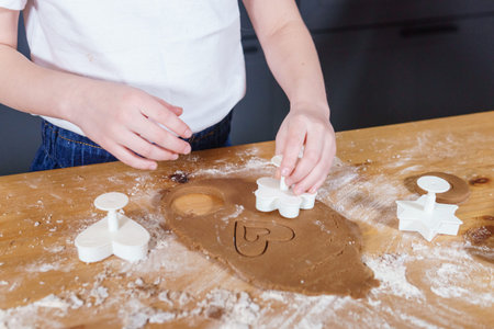 A little girl makes heart-shaped cookies from rye dough. The concept of Valentines Day and healthy...