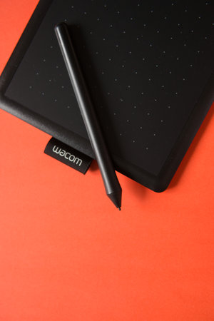 Tver, Russia - February 3, 2020 Top view of Wacom graphic tablet on red background. Space for text.のeditorial素材