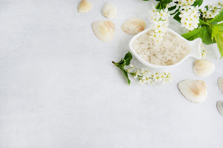 Concept of Spa-cosmetic and cosmetic procedures. Spa-sea salt in white dishes and seashells on light...