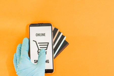 Close-up of hands in medical gloves with a smartphone. Online shopping, online banking, online...