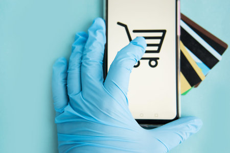 Close-up of hands in medical gloves with a smartphone. Online shopping, online banking, online...