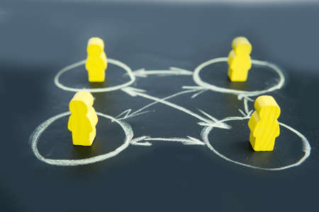 Social distance. Figures of yellow men on a black background. Maintaining social distance during coronovirus.の写真素材