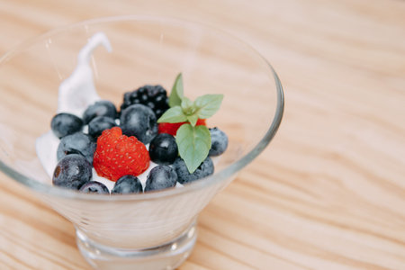Dessert with wild berries: blackberries, blueberries, raspberries. Cream with berries at a cooking class. Cooking at home.の写真素材