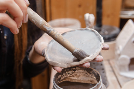 A master ceramist holds a clay product in his hands. Making a ceramic candle holder from clay. The...