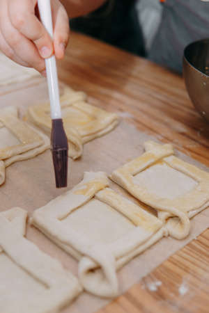 Preparing a dessert at a cooking master class. Baskets with peaches and strawberries, home cooking. Close-up, selective focus. Pastries, pies with peaches from puff pastry.の写真素材